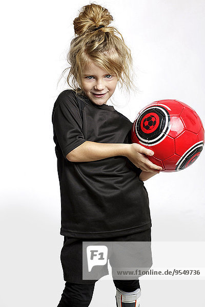 Porträt eines blonden Mädchens mit rotem Fußball in Fußballsportbekleidung vor weißem Hintergrund