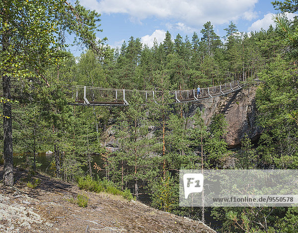 Finnland  Süd-Savonien  Kymenlaakso  Repovesi-Nationalpark  Junge über die Lapinsalmi-Hängebrücke laufen