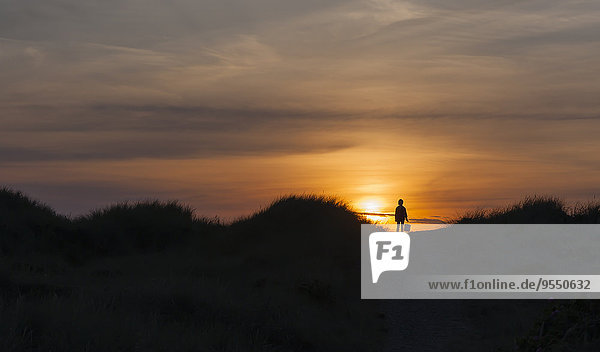 Denmark  Jutland  Lokken  girl in dune at sunset