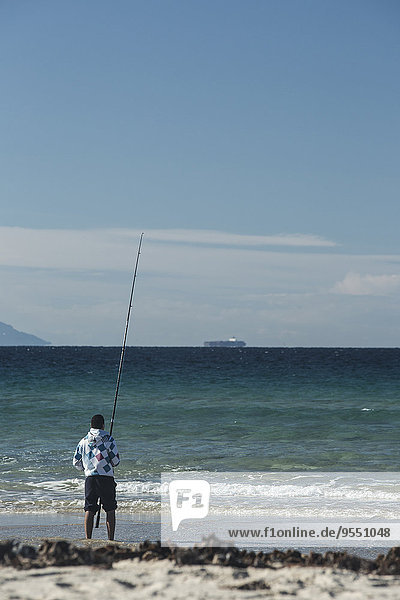 Spanien  Andalusien  Tarifa  Mann beim Fischen am Meer