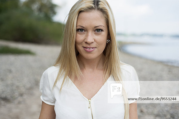 Porträt einer lächelnden jungen Frau am Strand