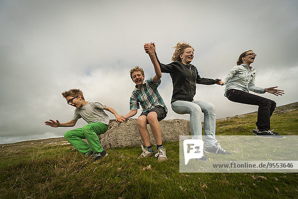 Großbritannien  England  Cornwall  Kinder springen aus Stein