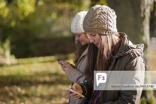 Deutschland  Rheinland-Pfalz  Studentinnen mit Smartphone im Außenbereich