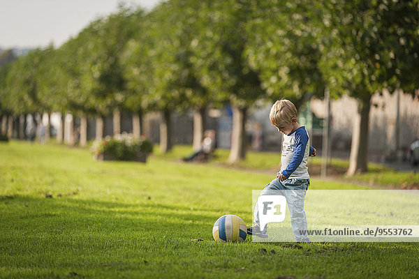 Junge spielt Fußball auf der Wiese
