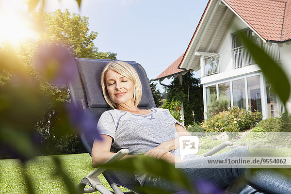 Relaxed woman in deck chair in garden