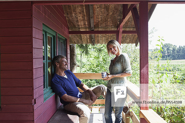 Happy mature couple on porch of summer house