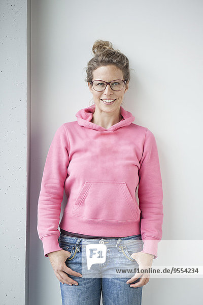 Porträt einer lächelnden reifen Frau in rosa Kapuzenjacke