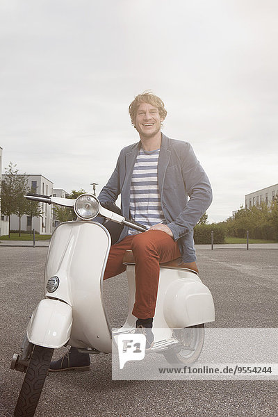 Happy man sitting on his motor scooter
