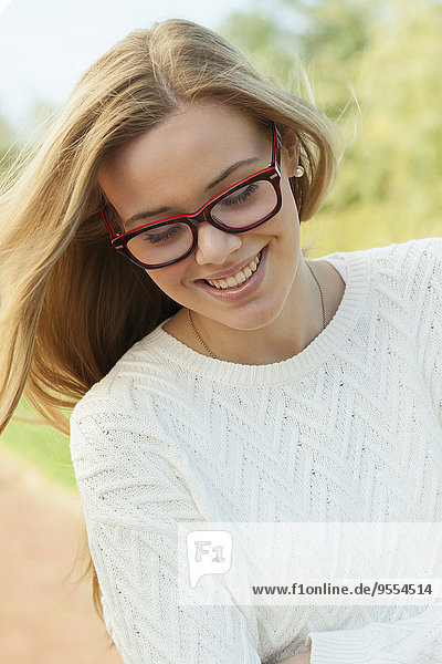 Porträt eines lächelnden blonden Teenagermädchens mit Brille