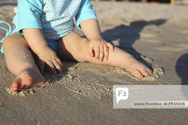 Kleines Mädchen beim Spielen am Sandstrand