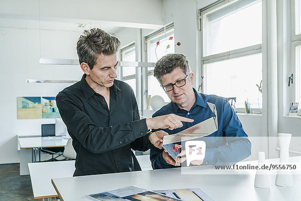 Two designers discussing workpiece in their studio