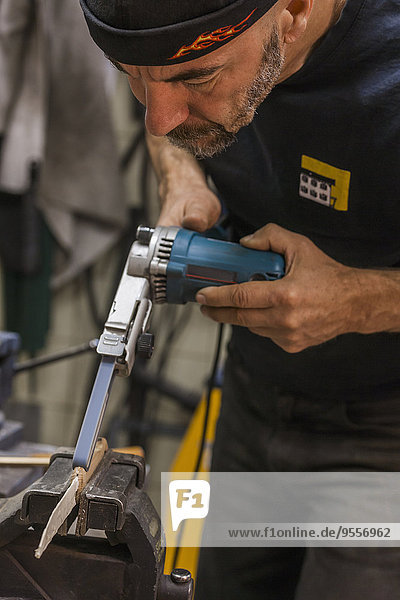 Knife maker in workshop at work