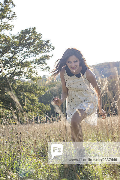 Junge Frau im Sommerkleid entspannt in der Natur