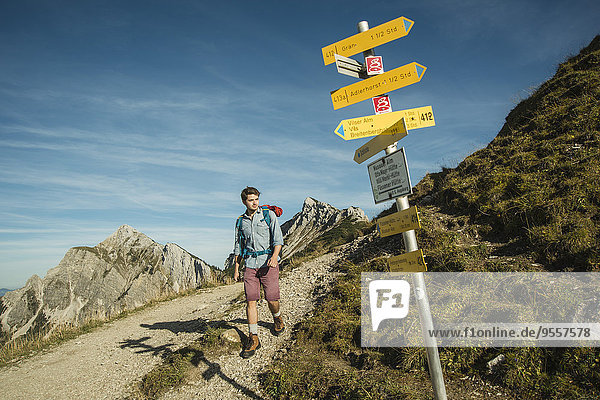 Austria  Tyrol  Tannheimer Tal  young man hiking on mountain trail