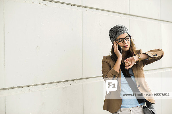 Junge Frau telefoniert mit dem Smartphone während der Zeitkontrolle