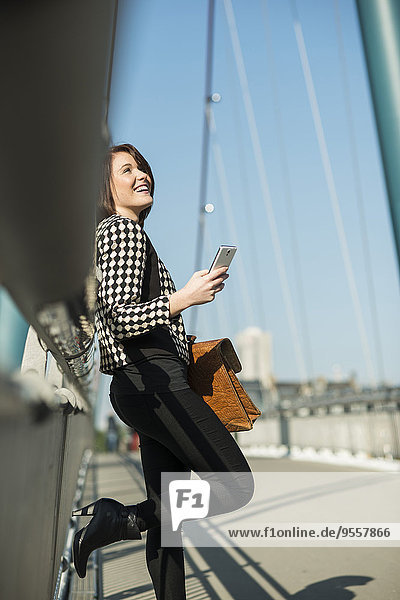 Deutschland  Frankfurt  junge Frau auf der Brücke per Handy