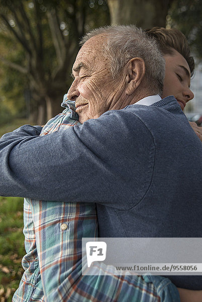 Enkel und älterer Mann umarmend
