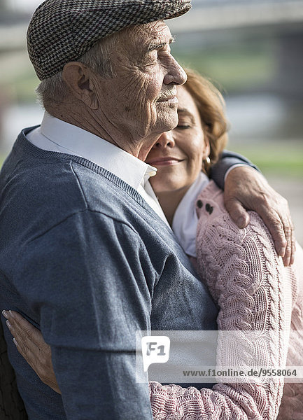 Tochter umarmt älteren Mann im Freien