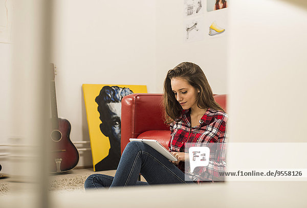 Junge Frau mit digitalem Tablett zu Hause