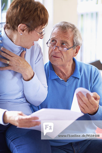 Senior couple reading document at home