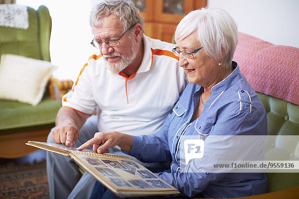 Seniorenpaar zu Hause beim Betrachten des Fotoalbums