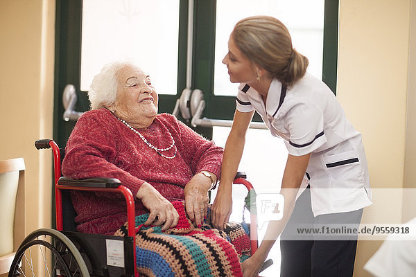 Nurse caring for senior woman in wheelchair