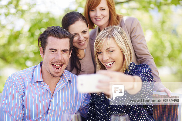 Glückliche Freunde nehmen Selfie mit nach draußen.