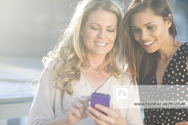 Zwei lächelnde Frauen auf dem Handy