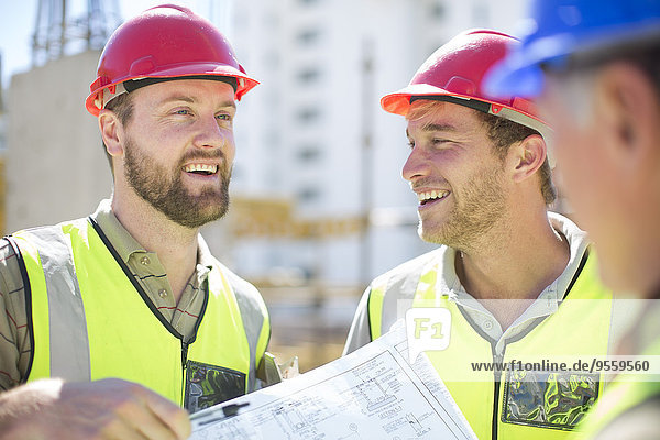 Construction workers discussing building plans in construction site