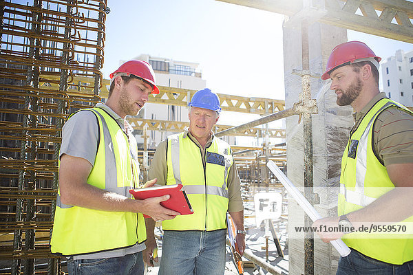 Drei Bauarbeiter im Gespräch auf der Baustelle