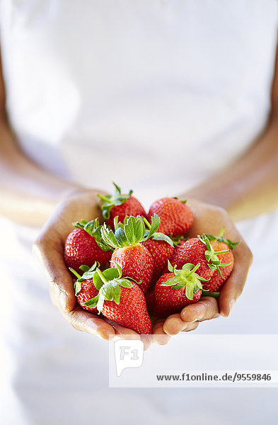 Frauenhände mit Erdbeeren in der Hand