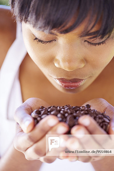 Woman holding coffee beans in her hands smelling