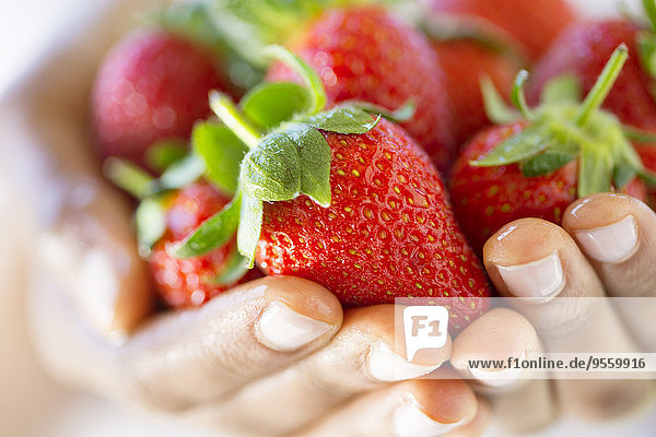Frauenhände mit Erdbeeren in der Hand