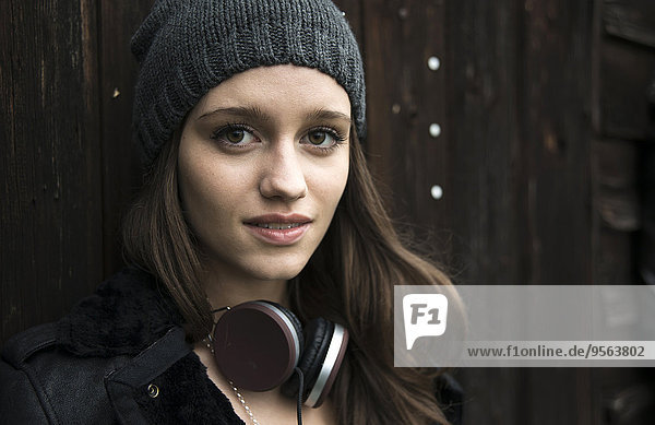 Außenaufnahme Portrait Jugendlicher sehen lächeln Kopfhörer Hut Close-up Blick in die Kamera Kleidung Mädchen freie Natur