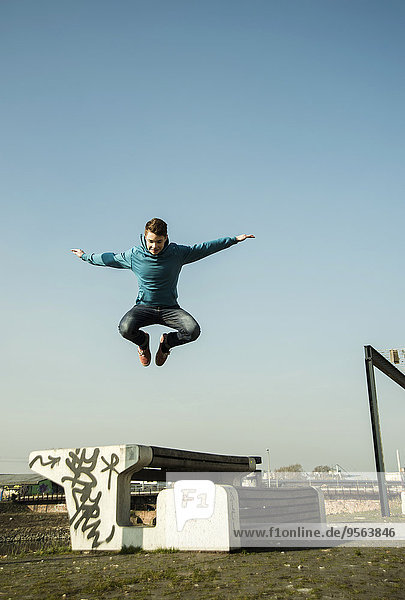 Außenaufnahme Jugendlicher Junge - Person über springen Sitzbank Bank freie Natur