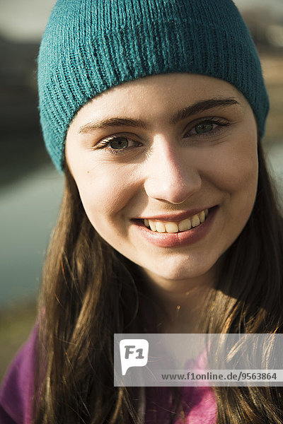 Close-up portrait of teenage girl outdoors wearing toque  smiling and looking at camera  Germany