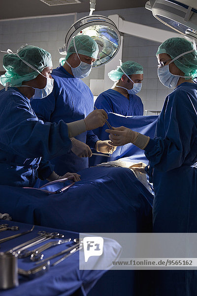 Ein OP-Team,  das einen Patienten in einem Operationssaal operiert.
