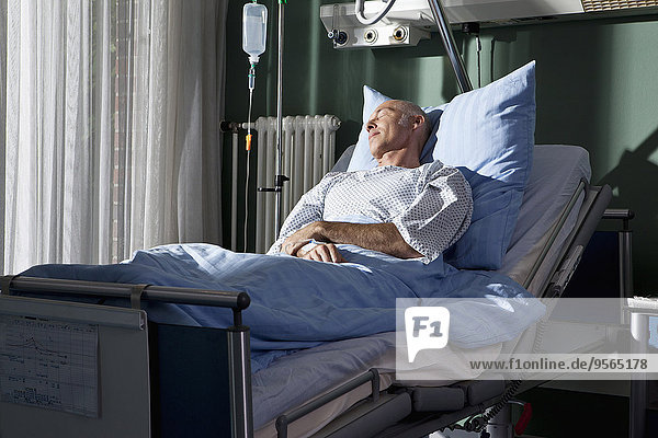 Ein Mann,  der in einem Krankenhausbett schläft.