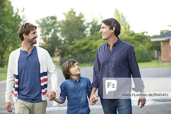 Fathers holding hands with son outdoors