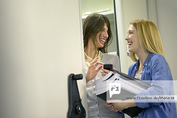 Women laughing together in office