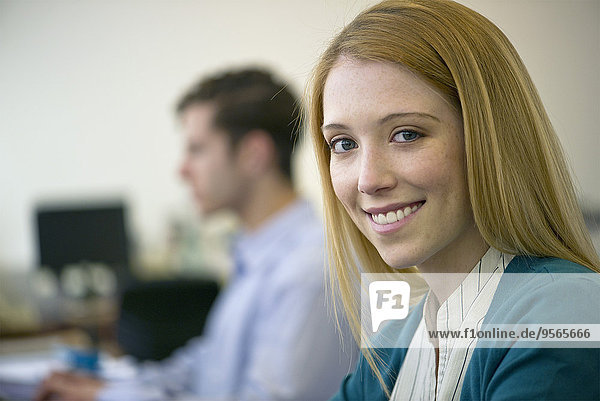 Junge Frau  die im Büro arbeitet  lächelt fröhlich.