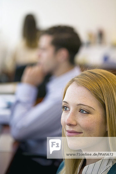 Young woman smiling dreamily in office