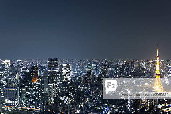 Beleuchteter Tokyo Tower inmitten des Stadtbildes gegen den Himmel bei Nacht