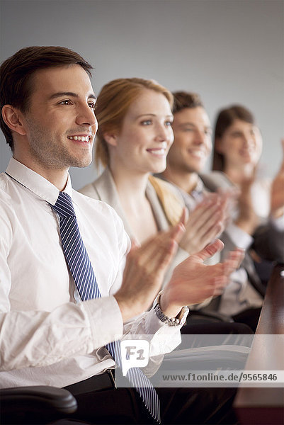 Young business professionals applauding during presentation