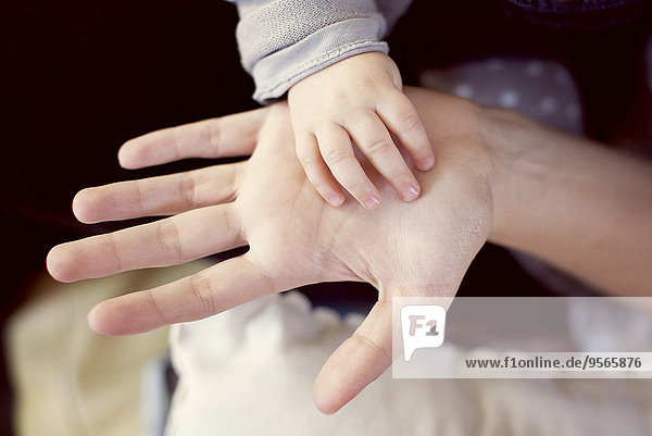 Babys Hand berührt die Hand eines Erwachsenen
