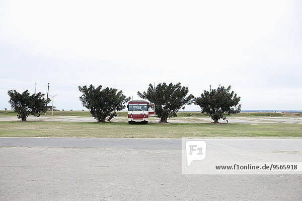 Vintage bus parked on ground by country road against sky