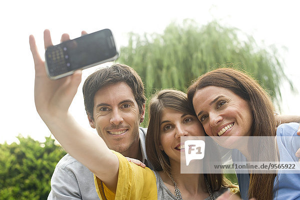 Young woman taking selfie with parents