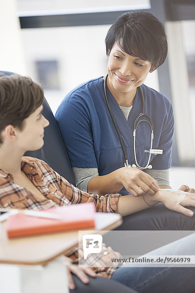 Ärztin im Gespräch mit einer jungen Patientin, die im Krankenhaus behandelt wird