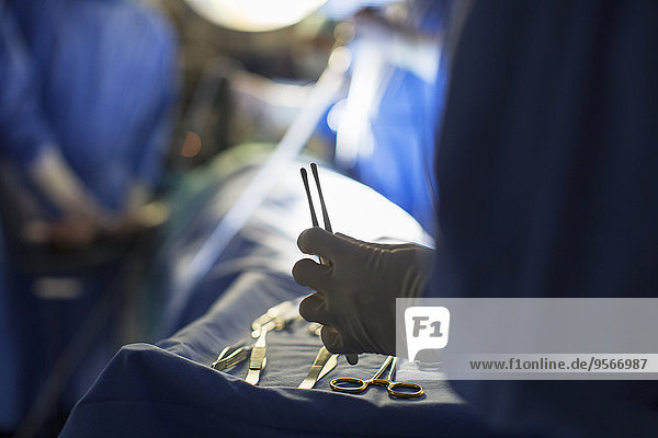 Krankenschwester mit chirurgischem Werkzeug während der Operation