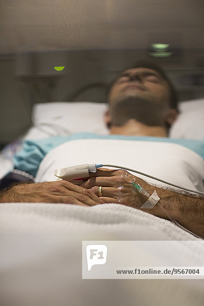 Männlicher Patient schläft im Krankenhausbett